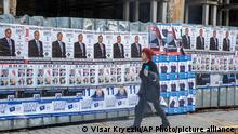 A pedestrian walks past election posters near a mosque under renovation, in the town of Kyustendil, Bulgaria, Saturday, April 3, 2021. After months of nationwide anti-government protests over corruption, stalled reforms and a stagnating economy in the EU's poorest member state, Bulgarians are gearing up for a parliamentary election in the shadow of the coronavirus pandemic. (AP Photo/Visar Kryeziu)