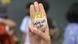 A demonstrator holds an egg reading sure we will win while signing a three-finger salute A demonstrator holds an egg reading sure we will win while signing a three-finger salute