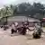 In this image made from video, soldiers and police officers assist residents to cross a flooded road in Malaka Tengah, Indonesia