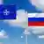 Флаги НАТО и России на фоне голубого неба