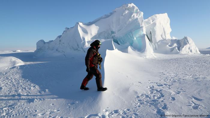 A researcher walks near ice hummocks