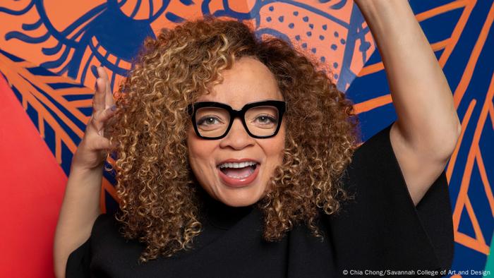 Clothing designer Ruth E. Carter stands in front of a colorful wall.