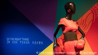 In an exhibition, a black mannequin wears a costume from the film Do the Right Thing, boxing gloves and a pink sportoufit, In an exhibition, a black mannequin wears a costume from the film Do the Right Thing, boxing gloves and a pink sportoufit,