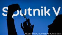 An illustrative image of a hand holding a medical syringe in front of the Sputnik V logo displayed on a screen. On Monday, February 1, 2021, in Dublin, Ireland. (Photo by Artur Widak/NurPhoto)