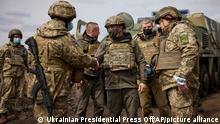 Wolodymyr Selenskyj, Präsident der Ukraine, schüttelt einem Soldaten die Hand, als er die Konfliktregion Donezk im Osten der Ukraine besucht. Der ukrainische Präsident Selenskyj besucht inmitten neuer Spannungen im Konfliktgebiet Donbass das Militär an der Frontlinie. +++ dpa-Bildfunk +++