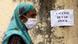 Woman walks past a sign saying "vaccine out of stock" in Mumbai Woman walks past a sign saying "vaccine out of stock" in Mumbai