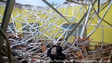 A local journalist films the damage to a class room at a school following an earthquake in Malang, East Java, Indonesia, Saturday, April 10, 2021. A strong earthquake damaged buildings on Indonesia's main island of Java and shook the tourist hotspot of Bali, officials said Saturday. No tsunami warnings were posted. (AP Photo/Hendra Permana)