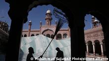 Volunteers clean the outer areas of a historical Mohabat Khan mosque ahead of the upcoming Muslim fasting month of Ramadan, in Peshawar, Pakistan, Friday, April 9, 2021. (AP Photo/Muhammad Sajjad)