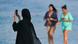 Women, one in hijab taking a selfie, on a beach in Dubai Women, one in hijab taking a selfie, on a beach in Dubai
