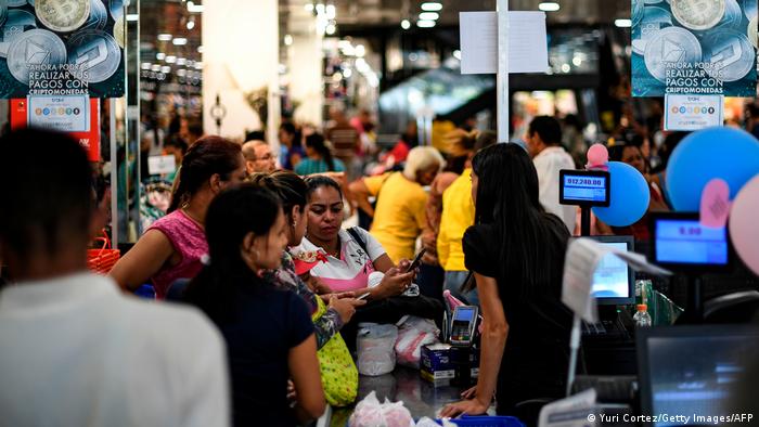 Customers stand in lines at the cashiers of a store that accepts the Venezuelan cryptocurrency Petro