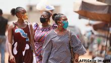Women wear masks made with African textiles as they walk through the Adidogomé Assiyeye market in Lome on April 17, 2020. - Togolese President Faure Gnassingbé on Wednesday evening declared a state of health emergency to prevent the spread of the coronavirus, which has already killed two people in the country for 36 cases identified and has ordered a remission of sentence for more than 1,000 prisoners. (Photo by - / AFP) (Photo by -/AFP via Getty Images)