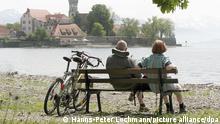 Ein Rentnerpaar erholt sich am Ufer des Bodensees auf einer Bank mit Blick auf die Wasserburg von den Anstrengungen einer Ausflugstour mit dem Fahrrad auf dem um das Gewässer führenden Bodensee-Radweg, aufgenommen am 15.05.2006. Foto: Hanns-Peter Lochmann +++(c) dpa - Report+++