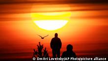 People watch the sunset over the Finnish Gulf coast in St. Petersburg, Russia, Wednesday, April 14, 2021. (AP Photo/Dmitri Lovetsky)