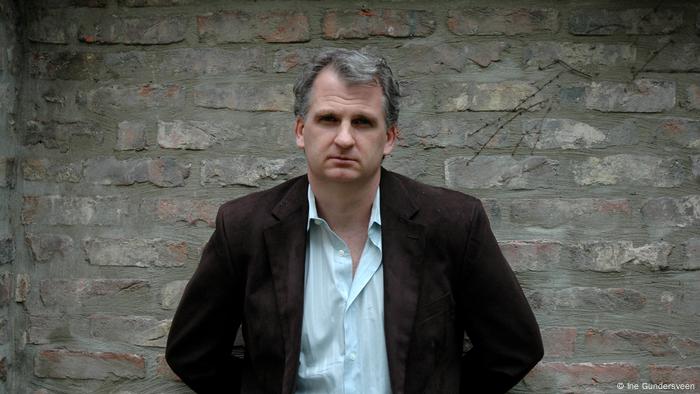 Timothy Snyder in front of a greyish brick wall