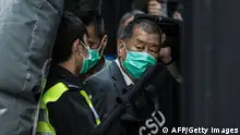 TOPSHOT - Media tycoon Jimmy Lai (R) is escorted into a Hong Kong Correctional Services van outside the Court of Final Appeal in Hong Kong on February 1, 2021, after being ordered to remain in jail while judges consider his fresh bail application, the first major legal challenge to a sweeping national security law Beijing imposed on the city last year. (Photo by STR / AFP) (Photo by STR/AFP via Getty Images)