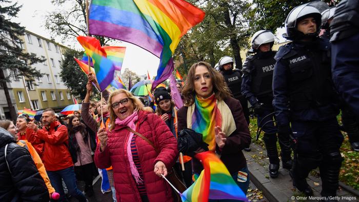 A woman holds a rainbow flag