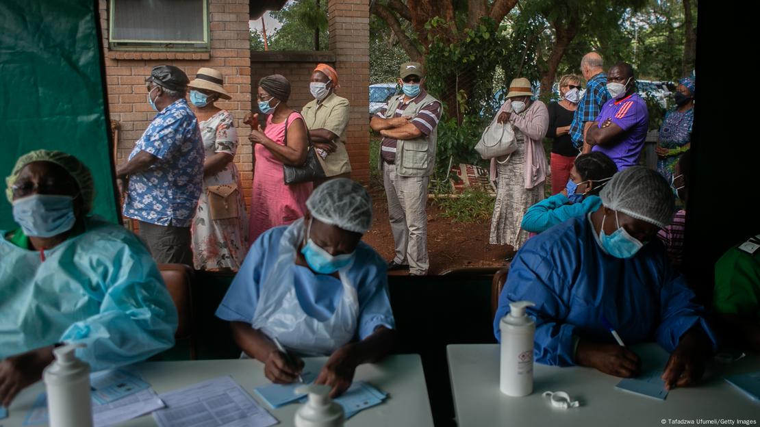 People line up outside of a tent where nurses from a local hospital are administering vaccines in Harare during the pandemic in 2021.