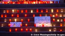 BERLIN, GERMANY - JANUARY 24: Candles and placards with numbers of the dead are making a makeshift memorial for COVID victims at Arnswalder Platz on January 24, 2021 in Berlin, Germany. The memorial is part of the initiative Corona-Tote sichtbar machen (lit. Make corona deaths visible) by Christian Y. Schmidt and Veronika Radulovic, since December 6, 2020, people gather at the fountain of Arnswalder Platz every Sunday, light candles and place placards with the current death toll reported in Germany at the time. The death toll in Germany by various sources have passed 50,000. (Photo by Omer Messinger/Getty Images)