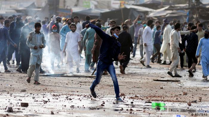 A TLP supporter hurls stones towards police in Lahore