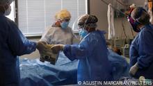 Healthcare workers check a patient suffering from the coronavirus disease (COVID-19), in an intensive care unit of a hospital on the outskirts of Buenos Aires, Argentina April 16, 2021. REUTERS/Agustin Marcarian