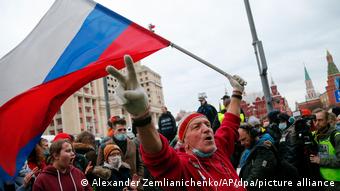 Мужчина с флагом России на митинге в поддержку Алексея Навального в Москве 21 апреля