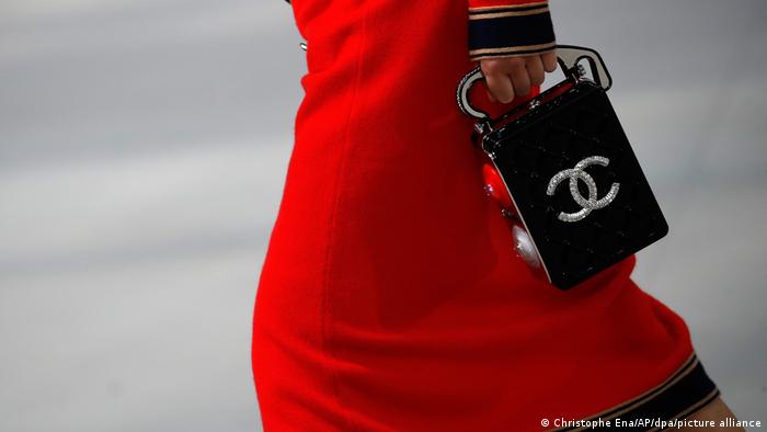 A woman holding a Chanel Logo purse