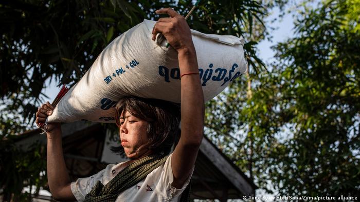 Eine Frau in Yangon trägt im Februar 2021 einen Sack Reis auf dem Kopf