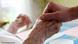 Una persona toma la mano de una anciana. Una persona toma la mano de una anciana.