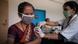 A woman receives a vaccine in New Dehli A woman receives a vaccine in New Dehli