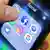 Foto simbólica de una mano con un teléfono celular que muestra apps de redes sociales en su pantalla.