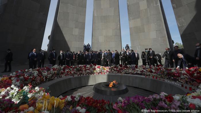 Pessoas ao redor de flores em um memorial