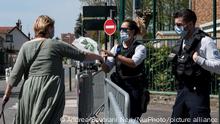 A policewoman receives a bouquet of flowers from a woman paying tribute to the police officer killed in an attack at the police station, in Rambouillet, Paris, on April 24, 2021. (Photo by Andrea Savorani Neri/NurPhoto)