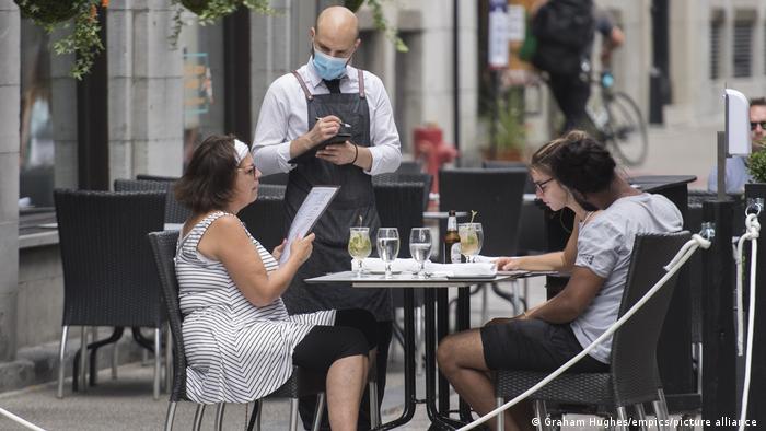  server wears a face mask as he takes an order at an outdoor terrace in Montreal