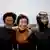 Three elderly women wearing wetsuits pictured on a rocky coastline