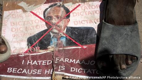 Demonstrators from Somali anti-government opposition groups stand on photographs of the president.
