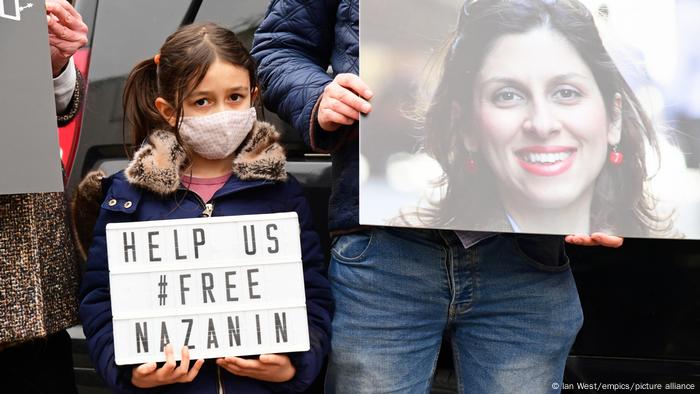 Nazanin Zaghari-Ratcliffe's daughter holds a sign at a protest outside the Iranian Embassy in London
