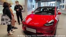 ©/MAXPPP - SHANGHAI, CHINA - APRIL 21: Customers watch a Tesla car at a Tesla experience store on April 21, 2021 in Shanghai, China. (Photo by Wang Gang/VCG)
