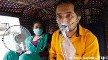 25.04.2021
A patient wearing an oxygen mask looks on as his wife holds a battery-operated fan while waiting inside an auto-rickshaw to enter a COVID-19 hospital for treatment, amidst the spread of the coronavirus disease (COVID-19) in Ahmedabad, India, April 25, 2021. REUTERS/Amit Dave