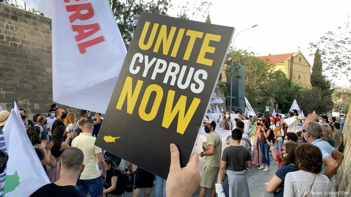 Demonstration, im Vordergrund ein Plakat mit der Aufschrift Zypern jetzt vereinigen