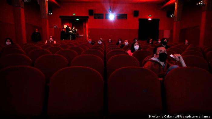 Kino-Besucher mit einem Mund-Nasen-Schutz in einem Saal 