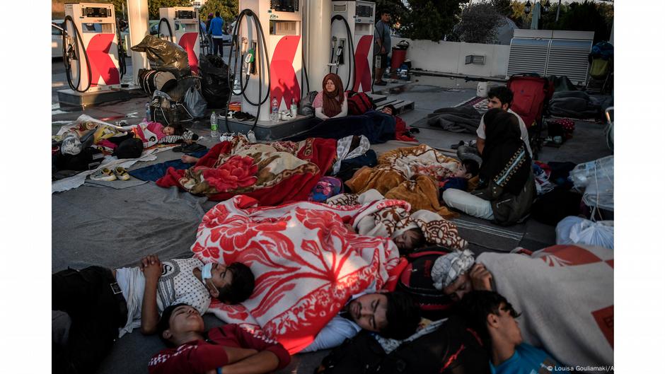 People sleeping on ground at gas station. Photo:| Louisa Gouliamaki, Lesbos, Greece