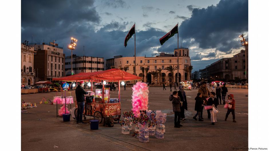 Candy stall lit up at twilight in the middle of a square. Photo: Ivor Prickett, Libya