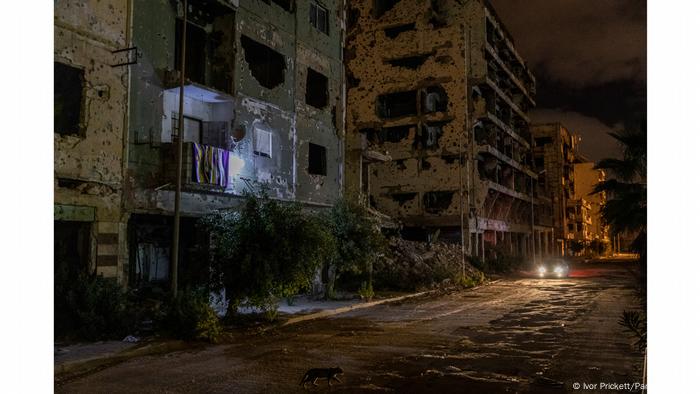 Foto noturna mostra prédios com marcas de destruição na Líbia