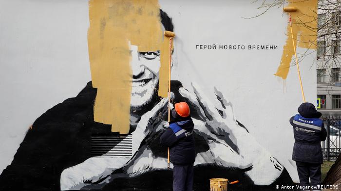Сотрудники коммунальных служб Санкт-Петербурга закрашивают граффити с портретом оппозиционного политика Алексея Навального и подписью Герой нового времени, апрель 2021 года