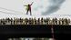 Un manifestante hace equilibrismo en un cable, mientras lo mira gente desde un puente, en Colombia, en 2021. Un manifestante hace equilibrismo en un cable, mientras lo mira gente desde un puente, en Colombia, en 2021.
