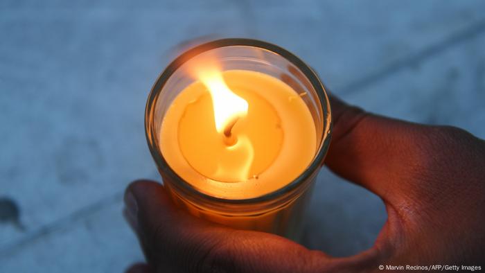 Foto simbólica de una mano con una vela