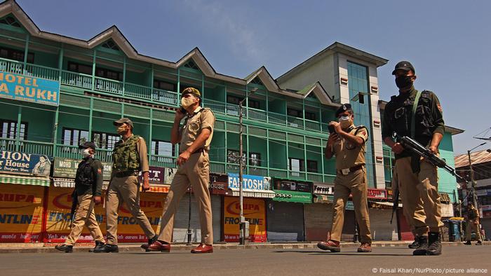 Indien: Mit Gewehren bewaffnete Polizisten mit Mundschutzen patrouillieren auf einer Straße Indien: Mit Gewehren bewaffnete Polizisten mit Mundschutzen patrouillieren auf einer Straße
