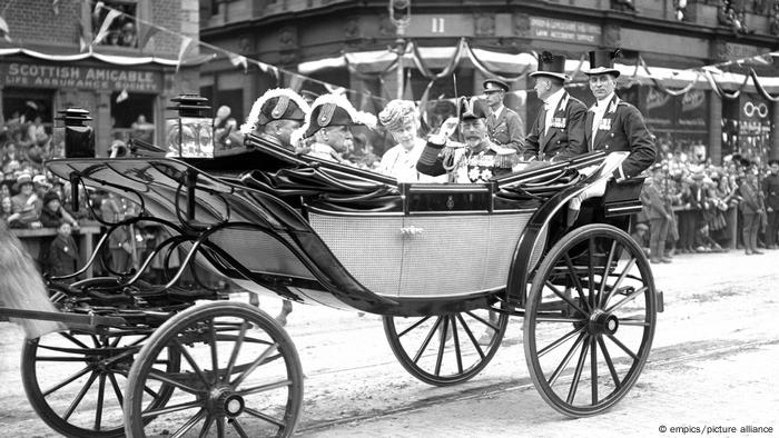 Queen Mary und George V. mit Begleitern in einer Kutsche.