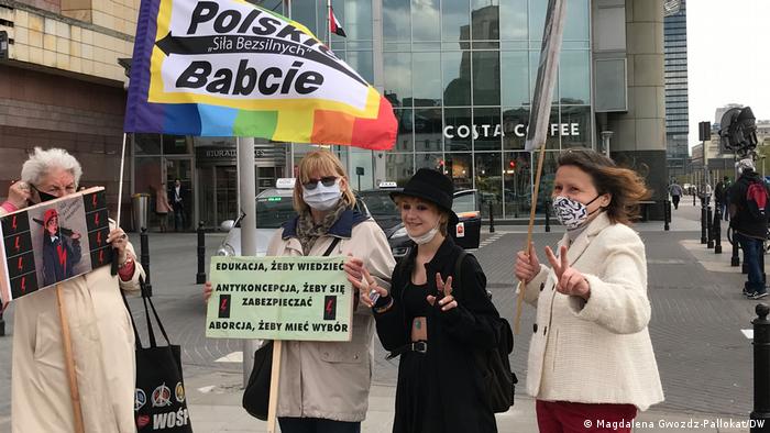Women pose for pictures wit the protesting Polish Grannies