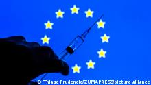 April 6, 2021, Barcelona, Catalonia, Spain: In this photo illustration, a close up of a hand holding a medical syringe seen displayed in front of the European Union flag. (Credit Image: Â© Thiago Prudencio/DAX via ZUMA Wire